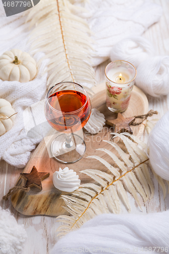 Image of Cosy still life for winter and autumn with glass of pink wine, pumpkin and cookie