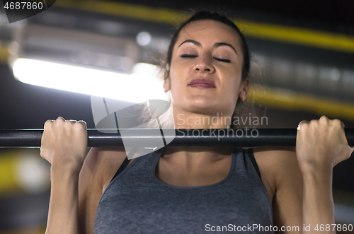 Image of woman doing pull ups on the horizontal bar