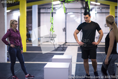 Image of athletes working out  jumping on fit box