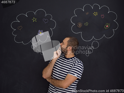 Image of young future father thinking in front of black chalkboard
