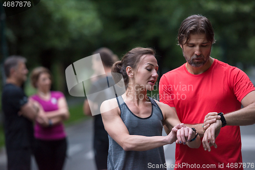 Image of sporty couple using smart watches