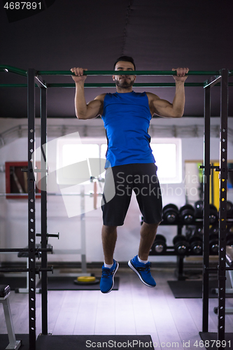 Image of man doing pull ups on the horizontal bar