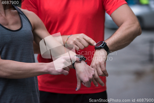Image of sporty couple using smart watches
