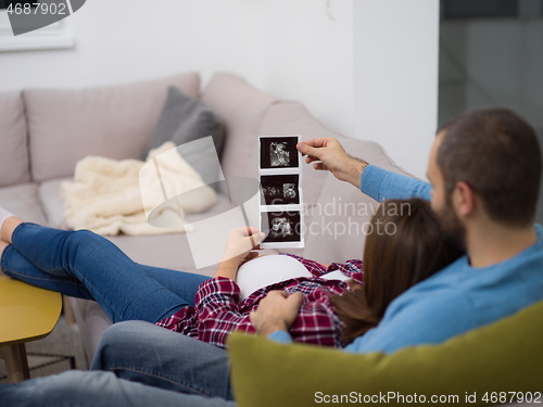Image of pregnant couple looking baby\'s ultrasound