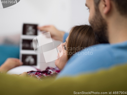 Image of pregnant couple looking baby\'s ultrasound