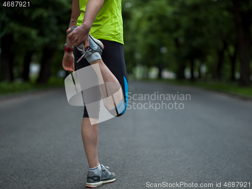 Image of female runner warming up and stretching before morning training