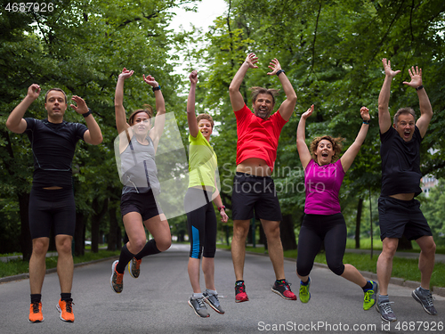 Image of runners team jumping in the air during  morning training