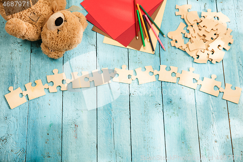 Image of Concept of mock up and pieces of puzzles on the background of wooden table