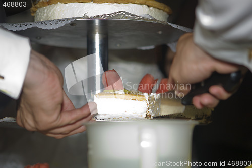 Image of Groom cutting wedding cake