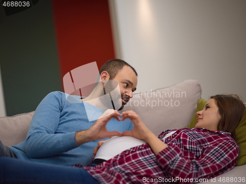 Image of man and pregnant woman showing heart sign