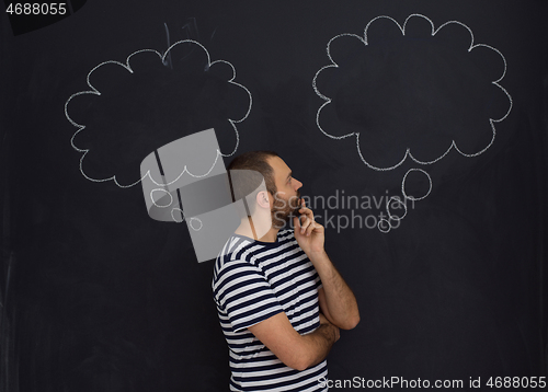 Image of young future father thinking in front of black chalkboard