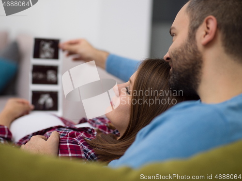 Image of pregnant couple looking baby\'s ultrasound