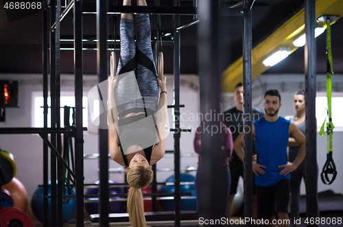 Image of woman working out with personal trainer on gymnastic rings