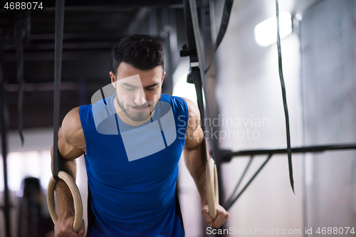 Image of man working out pull ups with gymnastic rings