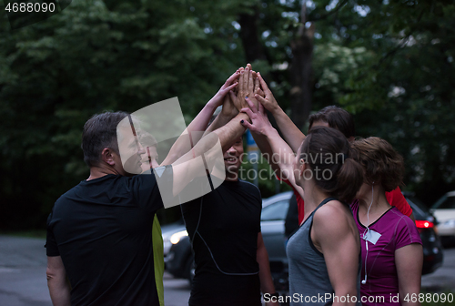 Image of runners giving high five to each other