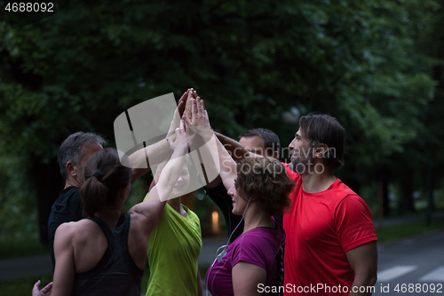 Image of runners giving high five to each other