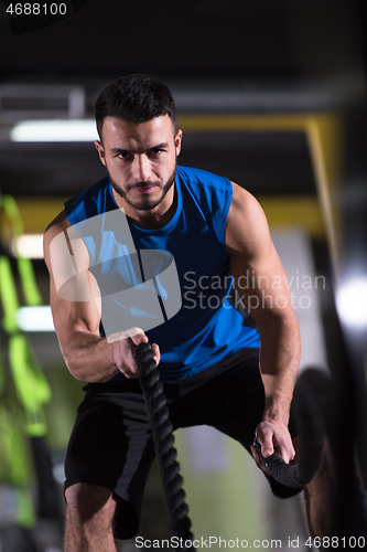 Image of athlete man doing battle ropes cross fitness exercise