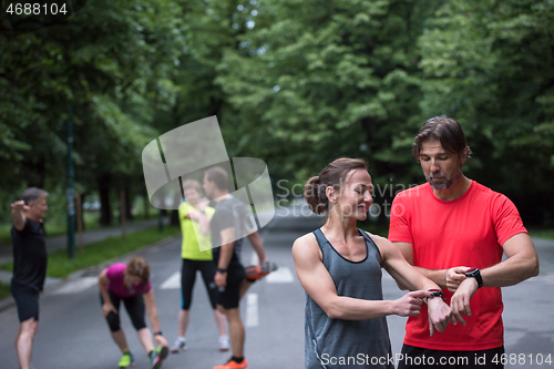 Image of sporty couple using smart watches