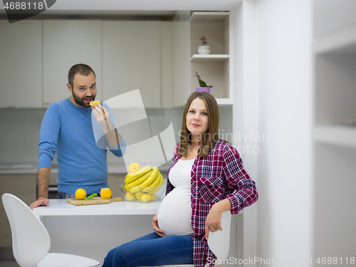 Image of couple cooking food fruit lemon juice at kitchen