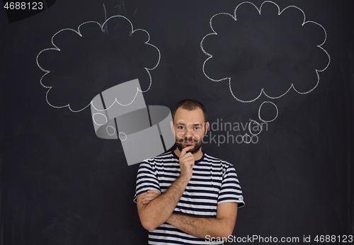 Image of young future father thinking in front of black chalkboard