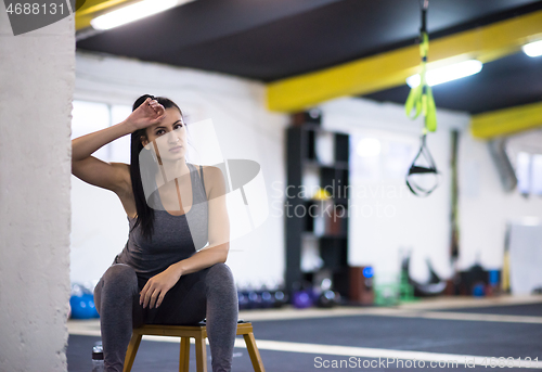 Image of young athlete woman sitting and relaxing