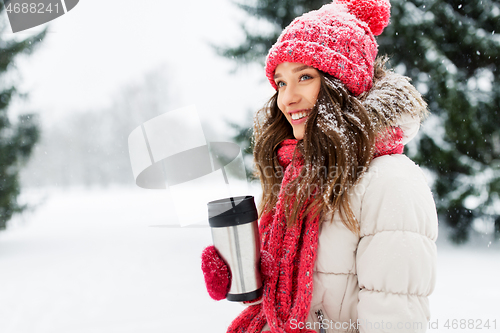 Image of young woman with hot drink in tumbler in winter