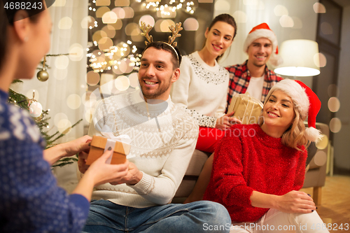 Image of friends celebrating christmas and giving presents