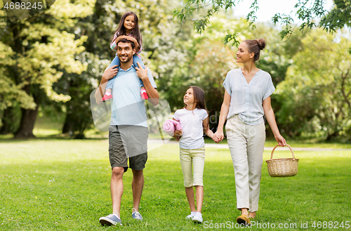 Image of family with picnic basket walking in summer park