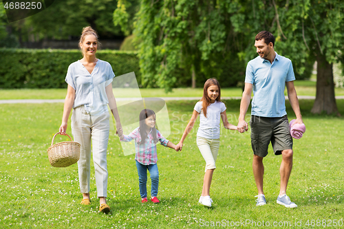 Image of family with picnic basket walking in summer park