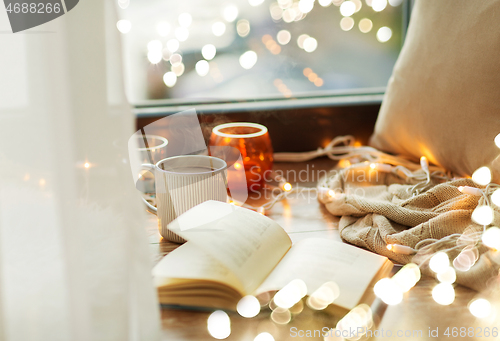 Image of book and coffee or hot chocolate on window sill