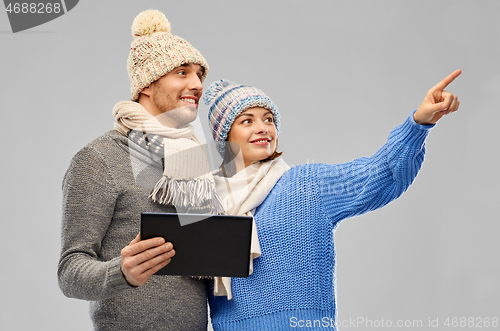 Image of couple in winter clothes with tablet computer