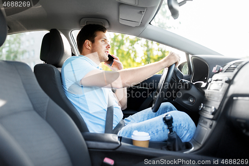 Image of man driving car and calling on smartphone