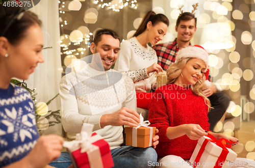 Image of friends celebrating christmas and opening presents