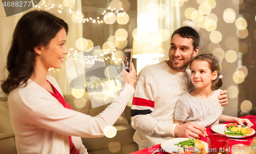 Image of happy family taking picture at christmas dinner