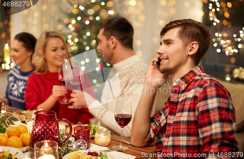 Image of man calling on smartphone at christmas dinner