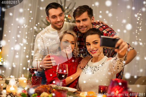 Image of friends taking selfie at christmas dinner