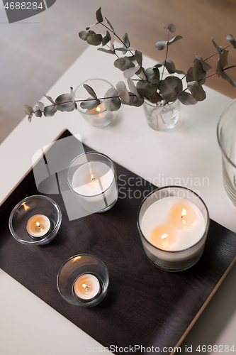 Image of candles and branches of eucalyptus on table