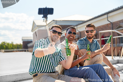 Image of men drinking beer and taking selfie by smartphone