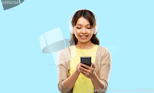 Image of asian woman in headphones listening to music