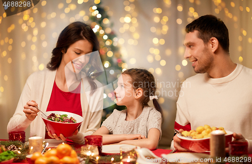 Image of happy family having christmas dinner at home