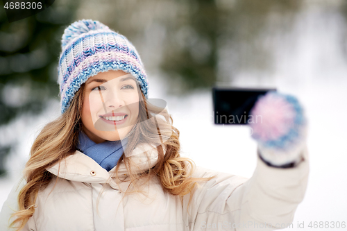 Image of woman taking selfie by smartphone in winter