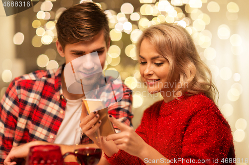 Image of couple with smartphone at home christmas dinner