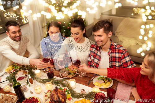 Image of friends celebrating christmas and drinking wine