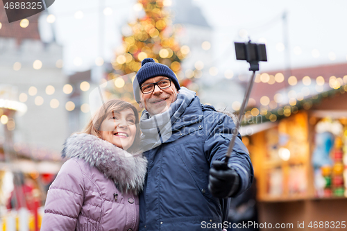 Image of senior couple taking selfie at christmas market