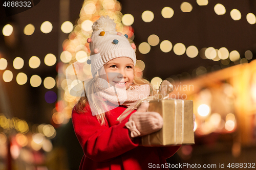 Image of happy girl with gift box at christmas market