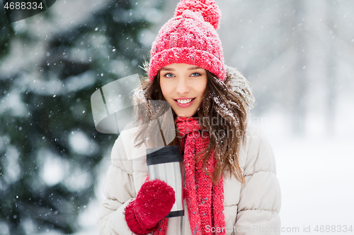 Image of young woman with hot drink in tumbler in winter