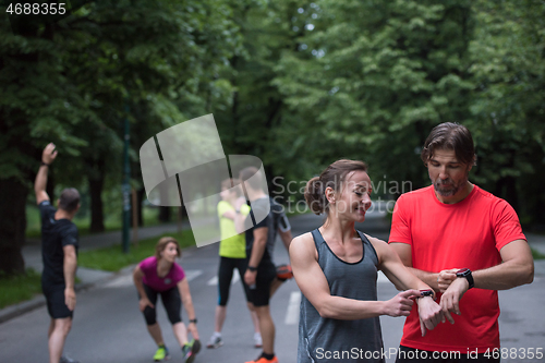 Image of sporty couple using smart watches