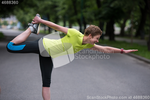 Image of female runner warming up and stretching before morning training