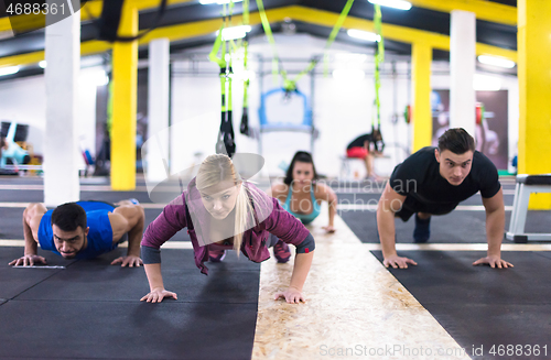 Image of young healthy people doing pushups