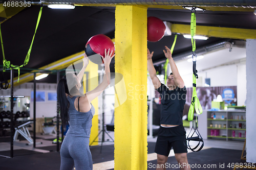 Image of young athletes couple working out with medical ball